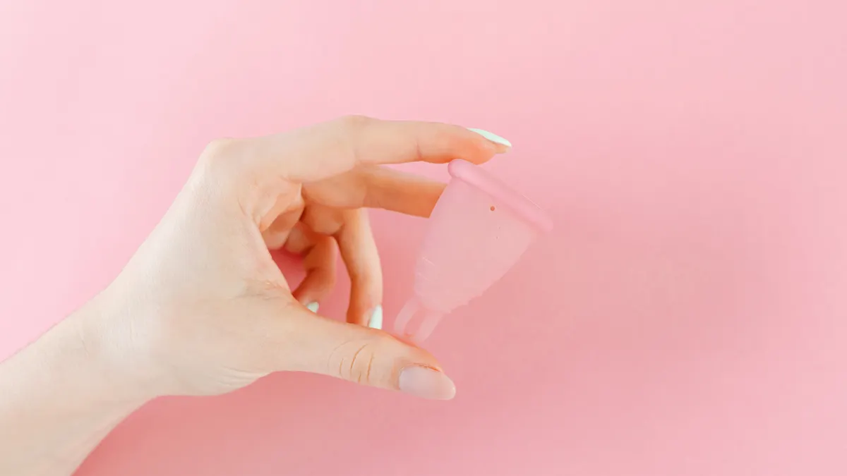Hand holding a translucent menstrual cup